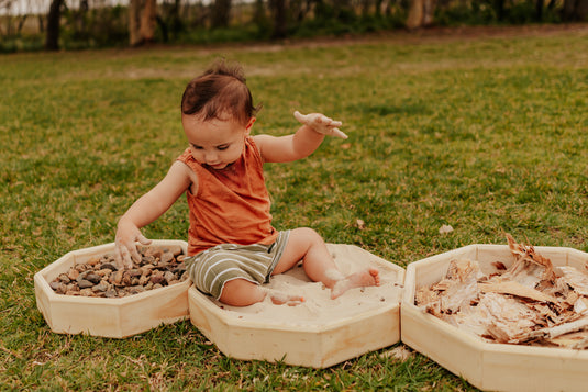 Child playing with natural materials in outdoorandbox
