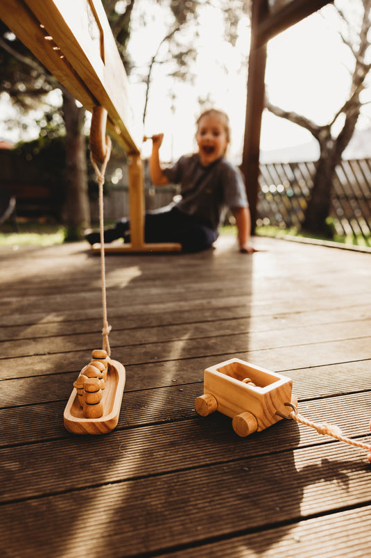 Child playing with wooden toys on a wooden deck