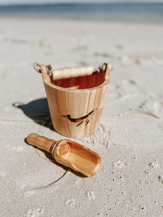 Wooden bucket and scoop on a sandy beach