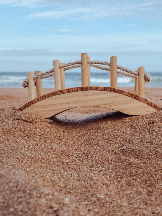 Wooden bridge on a sandy beach with ocean and sky in the background